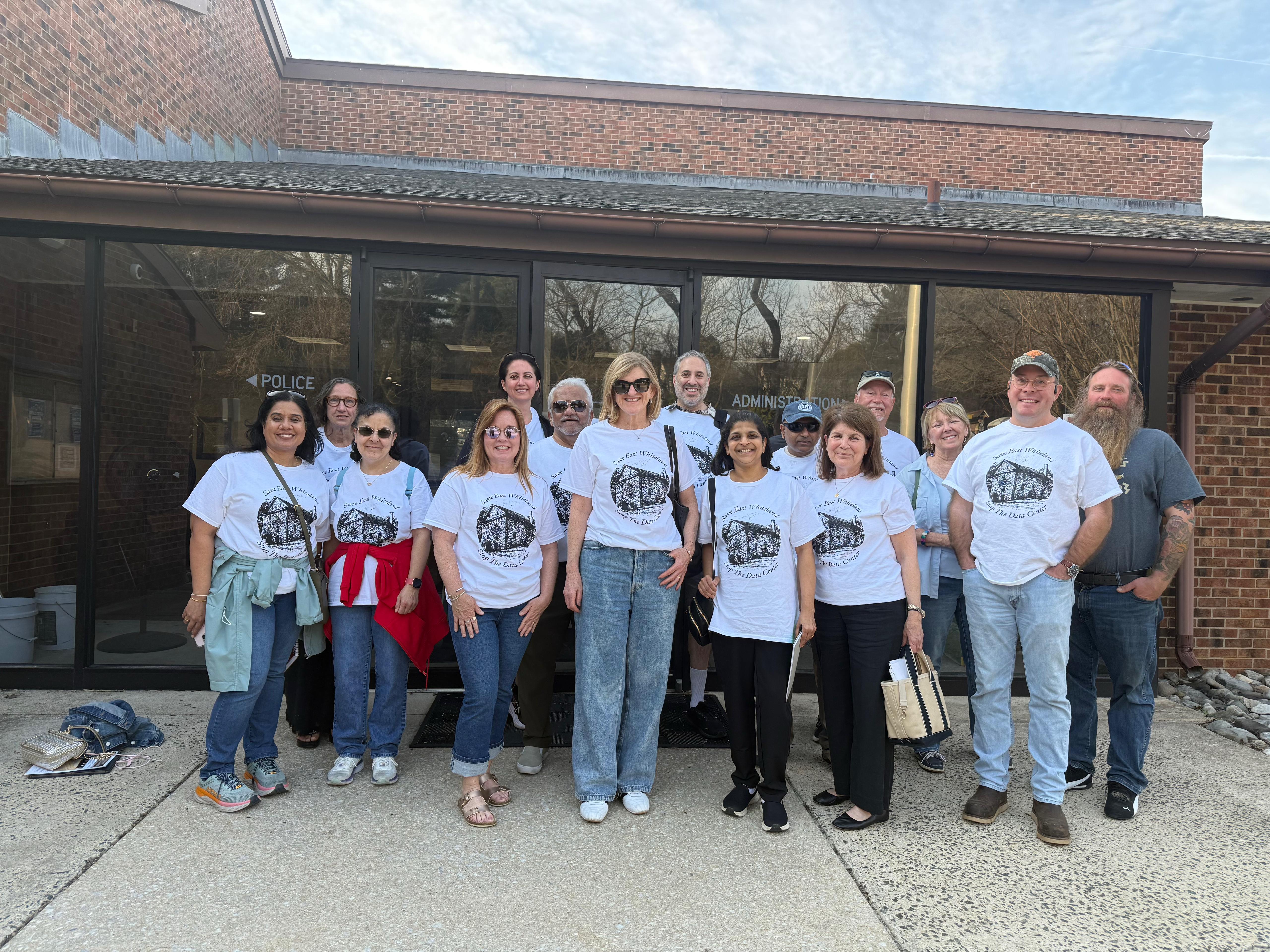 A group of East Whiteland residents wearing 'Save East Whiteland, Stop the Data Center' shirts outside the Township building.